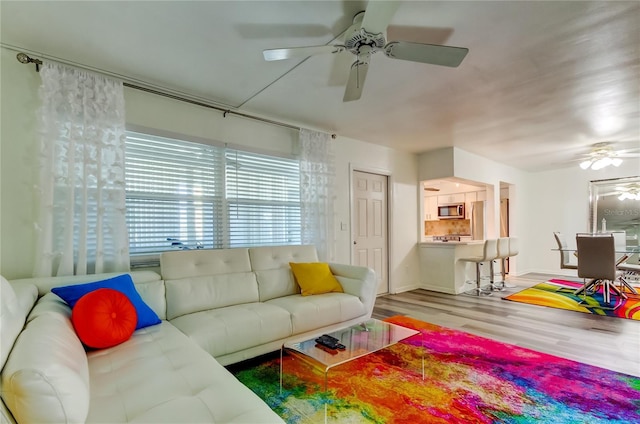 living room with hardwood / wood-style floors and ceiling fan