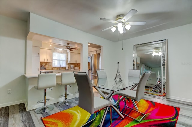 dining space featuring light hardwood / wood-style flooring and ceiling fan