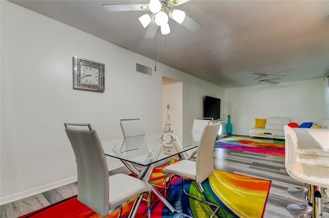 dining area with ceiling fan and hardwood / wood-style flooring