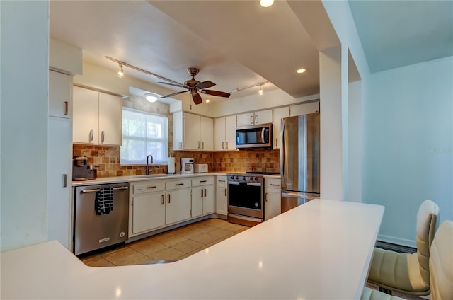 kitchen featuring backsplash, stainless steel appliances, and white cabinetry