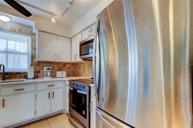 kitchen featuring white cabinets, sink, appliances with stainless steel finishes, and tasteful backsplash