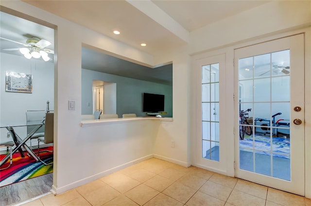 doorway featuring light tile patterned floors and ceiling fan