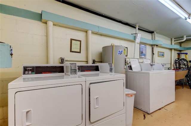 clothes washing area featuring washing machine and dryer and water heater