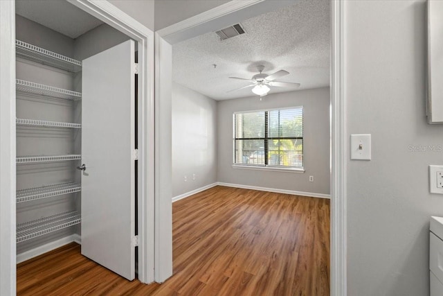 interior space featuring a textured ceiling, ceiling fan, a closet, and hardwood / wood-style floors