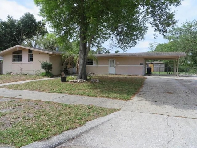 ranch-style home featuring a front yard and a carport