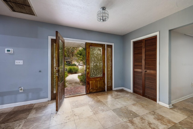 entrance foyer featuring an inviting chandelier and a textured ceiling