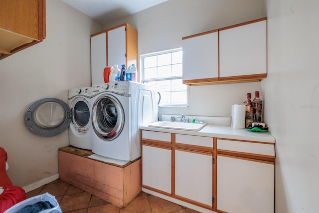 clothes washing area with cabinets, sink, light tile patterned floors, and independent washer and dryer