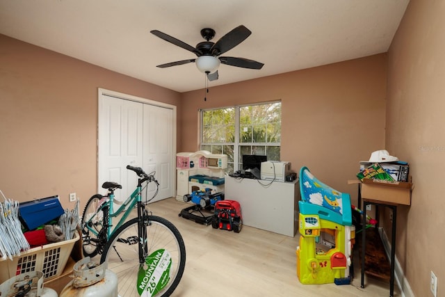 recreation room with ceiling fan and light hardwood / wood-style flooring