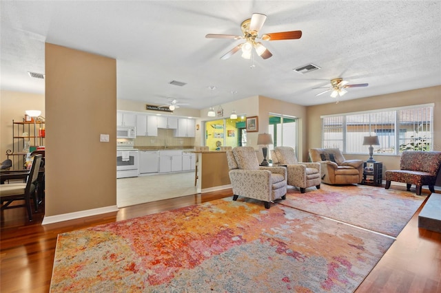 living room with dark hardwood / wood-style flooring and ceiling fan