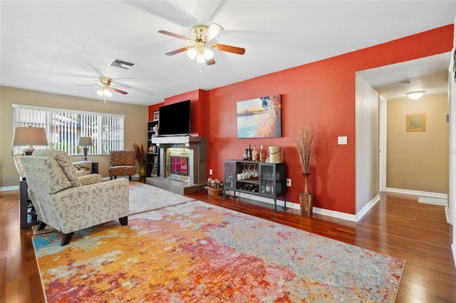 living room featuring hardwood / wood-style floors and ceiling fan