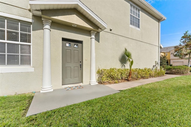 property entrance with covered porch and a lawn