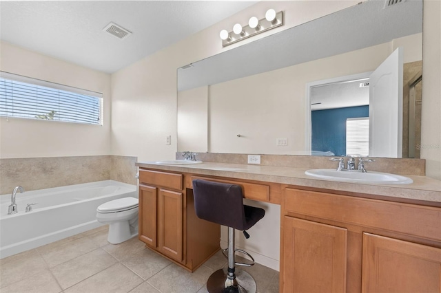 bathroom featuring a tub to relax in, vanity, toilet, and tile patterned flooring