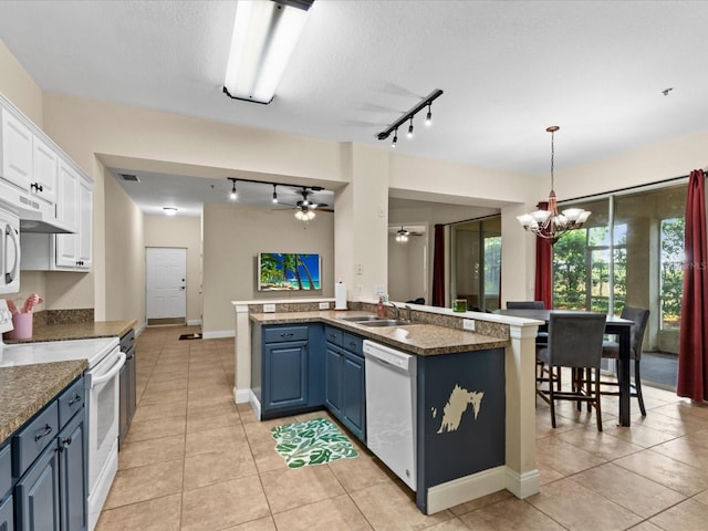 kitchen featuring white appliances, white cabinets, ceiling fan with notable chandelier, blue cabinets, and sink