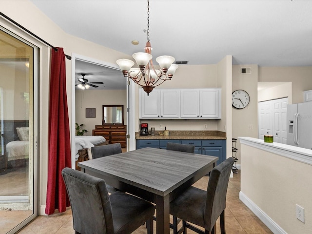 tiled dining area featuring ceiling fan with notable chandelier