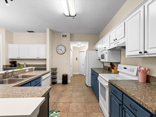 kitchen featuring white appliances, white cabinets, blue cabinets, sink, and light tile patterned floors