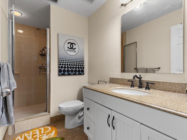 bathroom with tile patterned flooring, vanity, toilet, and walk in shower