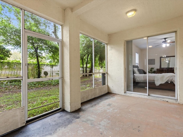 unfurnished sunroom with ceiling fan