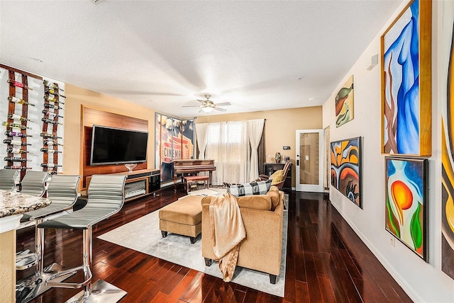 living room featuring ceiling fan, a textured ceiling, and hardwood / wood-style floors