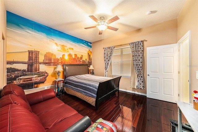 bedroom with ceiling fan, dark wood-type flooring, and a textured ceiling