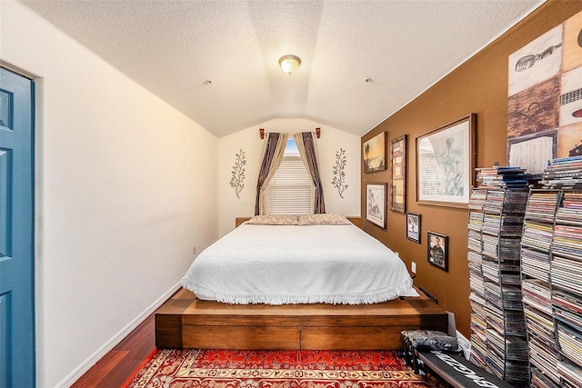 bedroom featuring wood-type flooring, lofted ceiling, and a textured ceiling