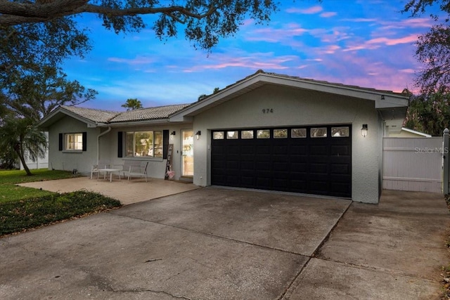 ranch-style home with a patio area and a garage