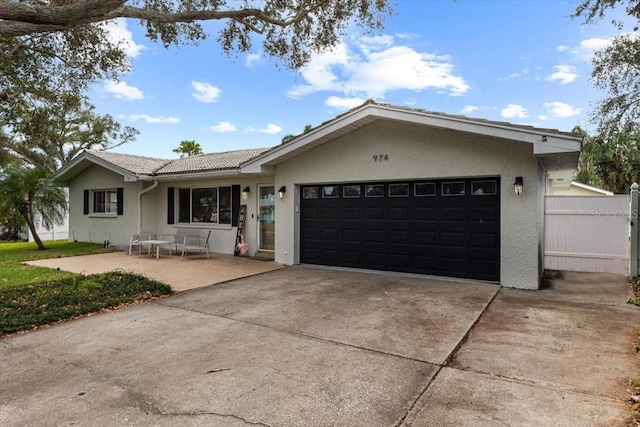 ranch-style home with a garage and a patio