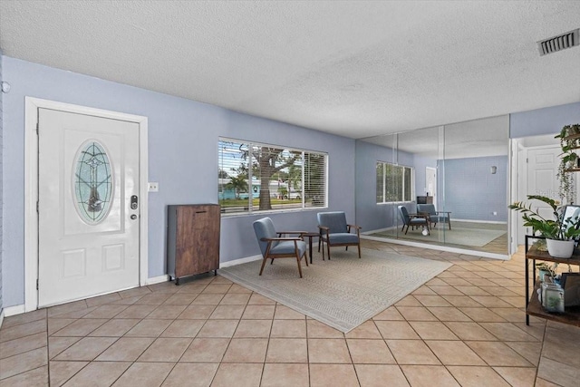 foyer with a textured ceiling and light tile patterned floors