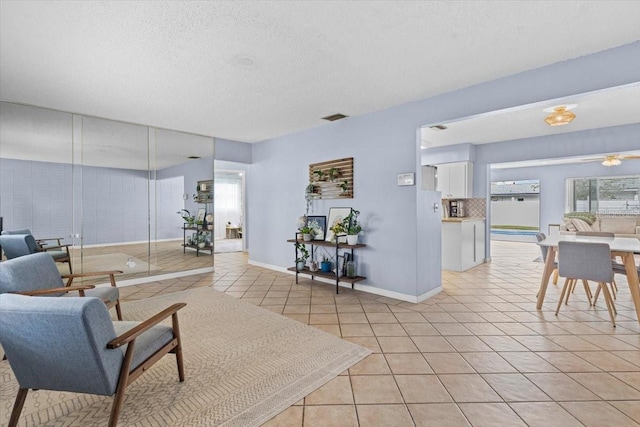 tiled living room with a textured ceiling and ceiling fan