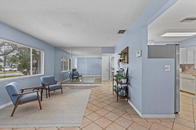 interior space featuring a textured ceiling and light tile patterned floors