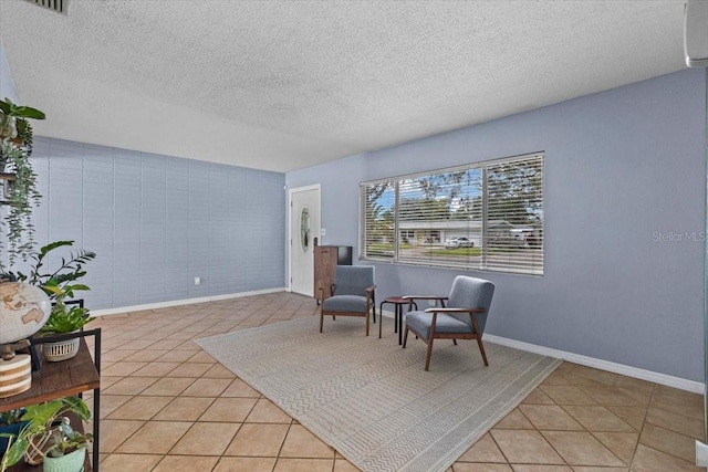 sitting room with a textured ceiling and light tile patterned flooring