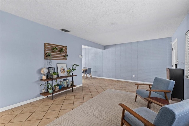 sitting room featuring a textured ceiling and light tile patterned floors