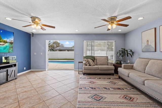 tiled living room with ceiling fan and a textured ceiling