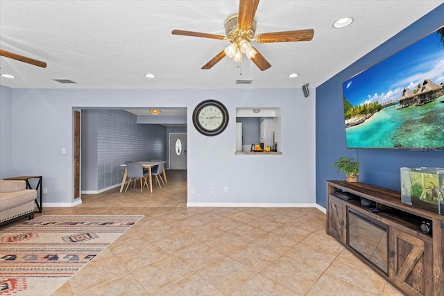 living room with a textured ceiling, brick wall, and light tile patterned floors