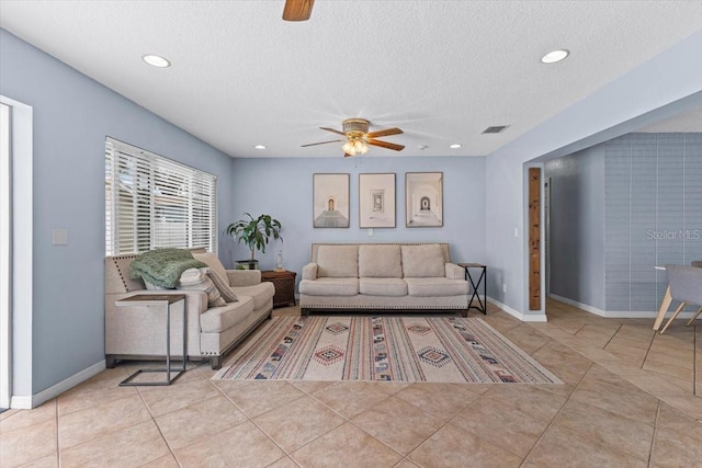 tiled living room featuring a textured ceiling and ceiling fan