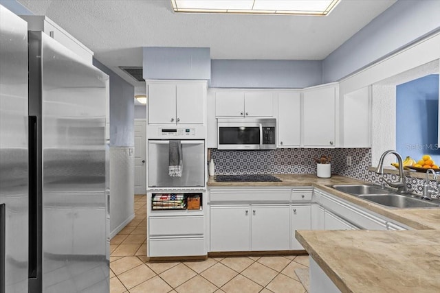 kitchen featuring white cabinets, appliances with stainless steel finishes, and sink