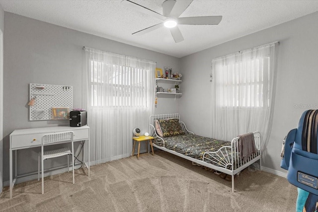 carpeted bedroom with a textured ceiling and ceiling fan