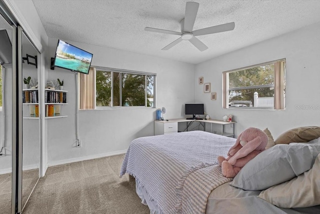 carpeted bedroom featuring ceiling fan, a textured ceiling, and a closet