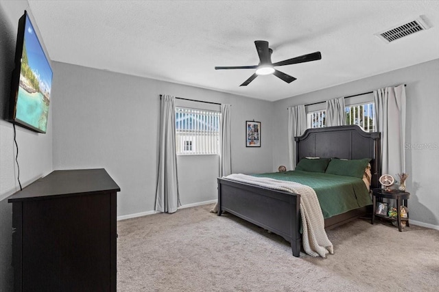 carpeted bedroom with a textured ceiling and ceiling fan