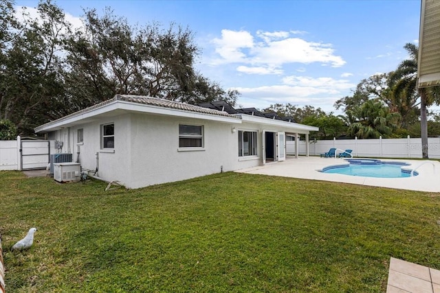 back of property featuring a patio area, a fenced in pool, and a yard