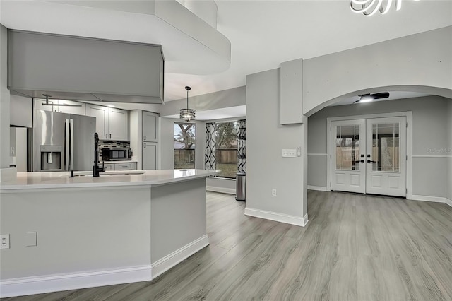 kitchen with french doors, sink, stainless steel fridge, decorative light fixtures, and gray cabinets