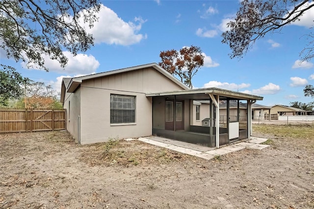 rear view of property featuring a sunroom