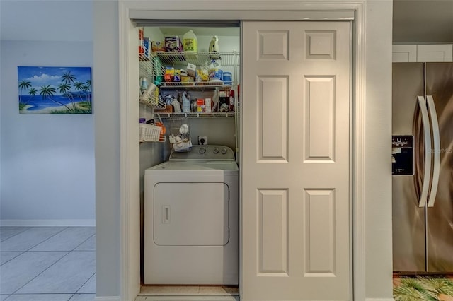 laundry room with light tile patterned floors and washer / dryer