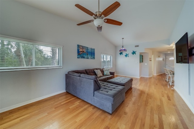 living room with ceiling fan, a healthy amount of sunlight, light wood-type flooring, and high vaulted ceiling