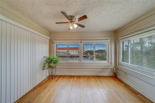 unfurnished sunroom with ceiling fan