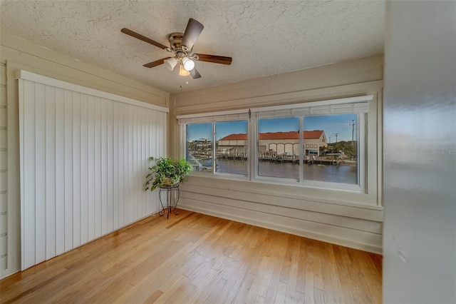 unfurnished sunroom featuring ceiling fan