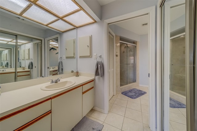 bathroom featuring an enclosed shower, vanity, and tile patterned flooring