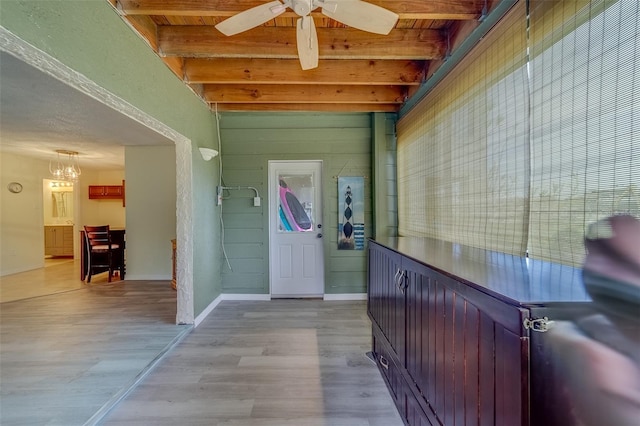 entryway featuring light wood-type flooring, ceiling fan with notable chandelier, and beamed ceiling