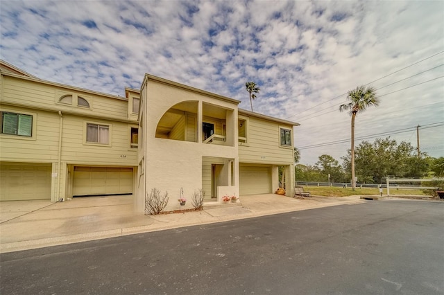 view of front of house featuring a garage and a balcony