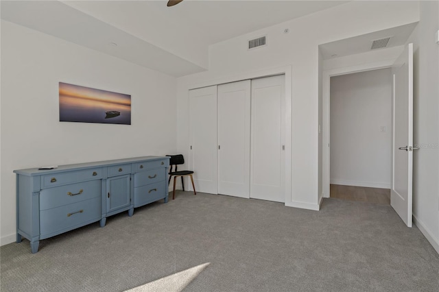 bedroom with ceiling fan, a closet, and light carpet