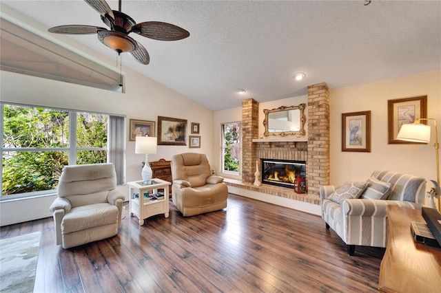 living room with a healthy amount of sunlight, dark wood-type flooring, a textured ceiling, and vaulted ceiling